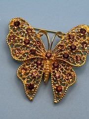Butterfly brooch filigree gold-plated metal base. Amber colored rhinestones